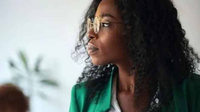 Une femme noire regarde sur le cote