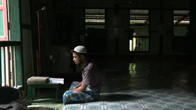 Seorang Rohingnya membaca ayat suci Alquran di masjid di lingkungannya tinggalnya di Hla Ma Chay, pinggiran kota Sittwe.