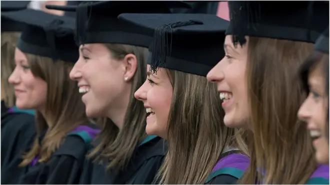 Students posing for celebration photographs after a graduation ceremony at Edge Hill University, Ormskirk, Lancashire