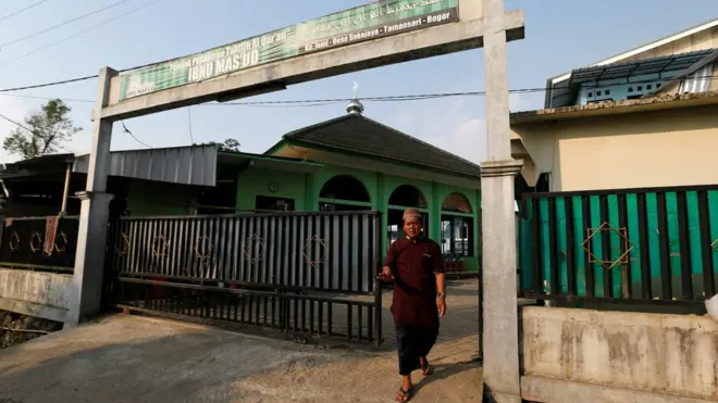 Seorang staf Pesantren Ibnu Mas'ud berjaga di depan pagar ketika dipotret, Juni 2017.