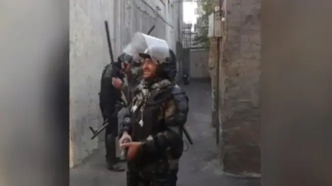 تصویری از یکی از ویدیوهایی که در آن نیروهای ضد شورش به منزل افراد حمله می‌کنند
