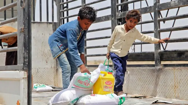 Two Yemeni children collect food aid. Ukraine supplies nearly a third of Yemen's wheat imports and there are heightened fears of a deepening famine