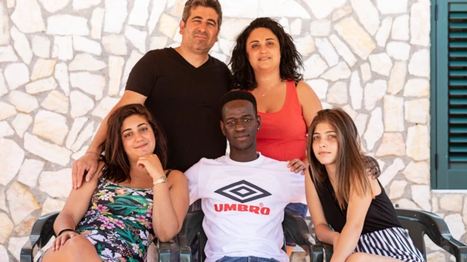 Mohamed "Lexy" Sanneh (au centre) entouré par les membres de la famille Ferraro, sa famille d'accueil