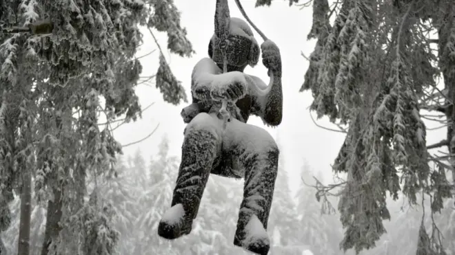 Вкрита снігом скульптура учасника гірських походів на горі Вассеркуппе біля міста Фульда в центральній Німеччині