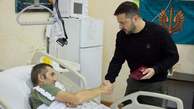 Ukraine's President Volodymyr Zelenskiy awards an injured Ukrainian serviceman in a hospital, on Day of the Ukrainian Armed Forces, amid Russia's attack on Ukraine, in Kyiv