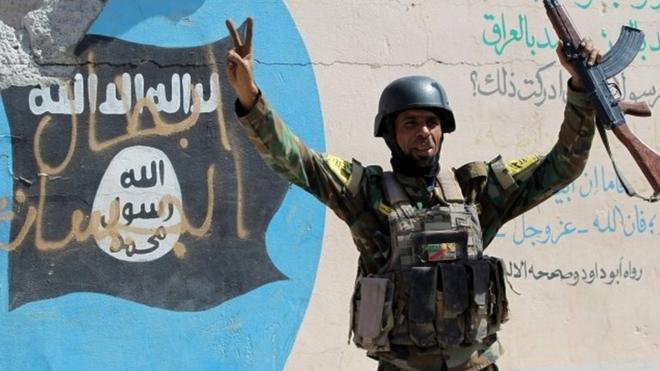 Iraqi soldier in front of IS graffiti in Sharqat, south of Mosul (23/09/16)