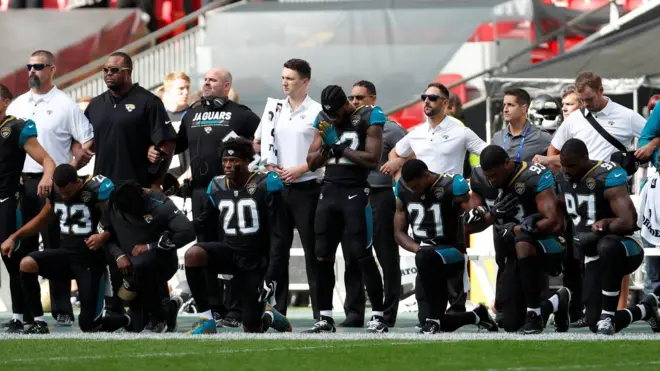 Jacksonville Jaguars players kneel during the U.S. national anthem