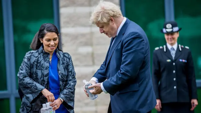 بوريس جونسون وبريتي باتيل يطهران أياديهم بغسول طبي.