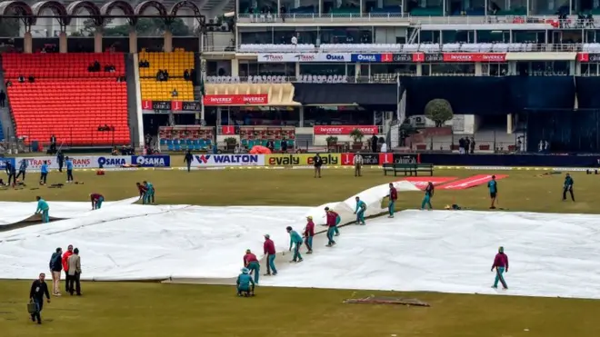 لاہور میں بارش کے باعث گراؤنڈ سٹاف پچ کو ڈھانپ رہا ہے