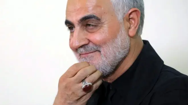 قاسم سليماني يداعب لحيته بأصابعه وقد ظهر خاتم بأصبعه البنصر.