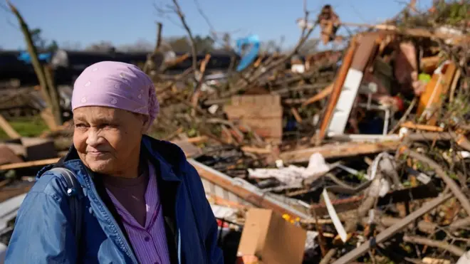 Clema Smith, who was trapped in the rubble, stands in front of the wreckage of her home in Wynne, Arkansas