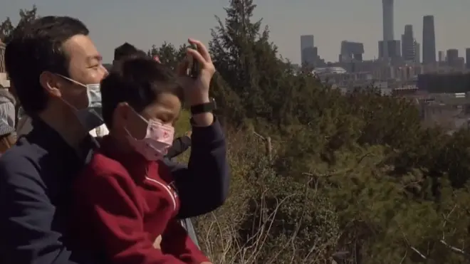 Čovek sa sinom u parku u Pekingu