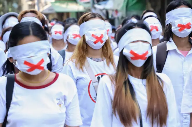 คนใส่หน้ากากรูปกากบาทสีแดง