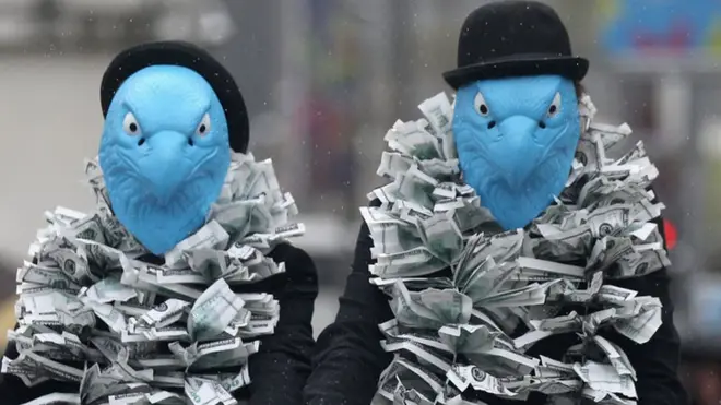 Protestors dressed as eagles protest against Barclays' senior management pay at the company's 2012 AGM