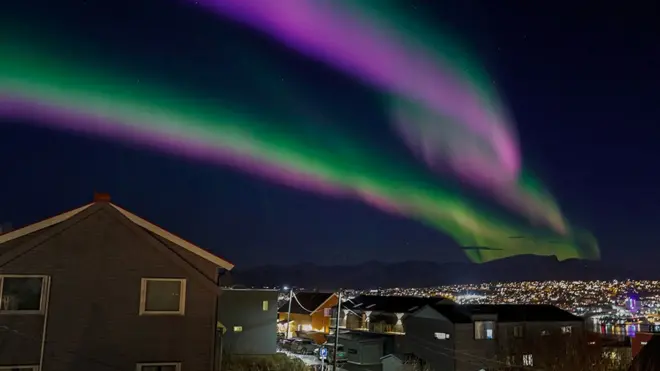Northern lights (aurora borealis) are seen over the city Tromsoe, Norway. The light-show happens when atoms in the Earth's high-altitude atmosphere collide with charged particles from the sun.