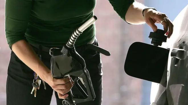 امرأة تملئ سيارتها بالوقود