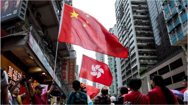 People hold the Chinese and Hong Kong flags as they take part in a pro-government rally in Hong Kong on August 17, 2014.