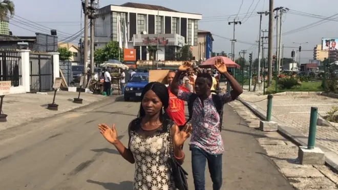 Pipo raise hand dey waka for security checkpoint