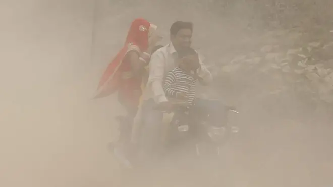 zagadjen vazduh nju delhi indija ljudi na motoru