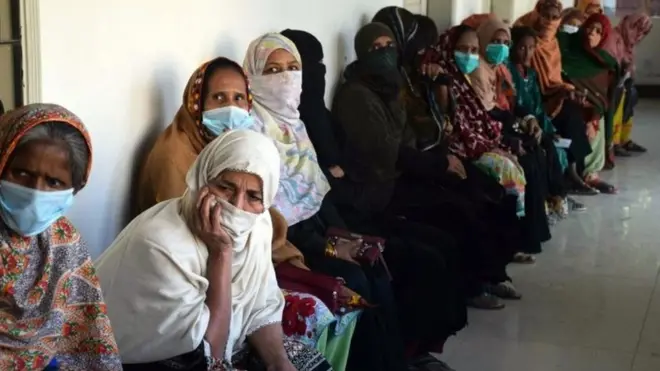 Warga Pakistan antre untuk menerima bantuan dalam pandemi Covid-19.