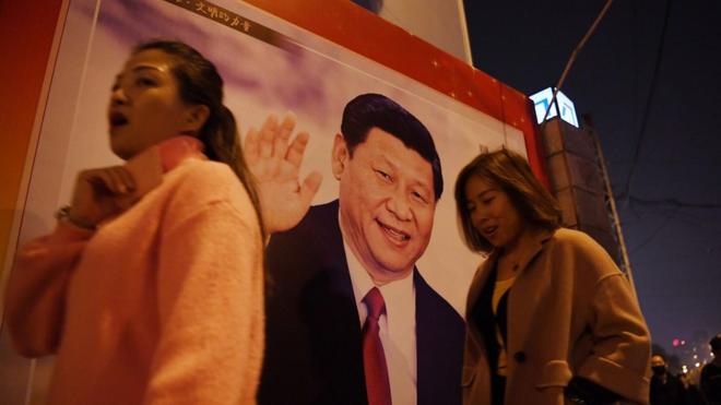 北京市民走在习近平的海报旁。