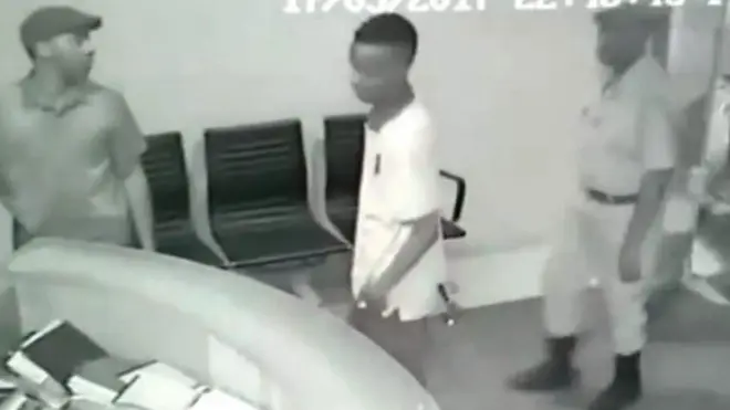 Kamera za CCTV zinamuonyesha mwanamume mwenye kofia akiingia studioni akiwa anasindikizwa na polisi waliojihami