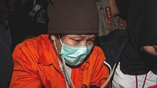 Buronan pelaku pembobolan Bank BNI Maria Pauline Lumowa (tengah) berjalan dengan kawalan polisi usai tiba di Bandara Internasional Soekarno-Hatta, Tangerang, Banten, Kamis (9/7/2020).