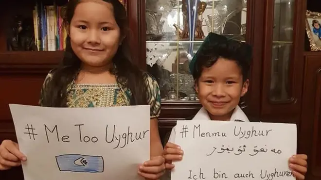 Dua anak mengusung poster bertuliskan #MeTooUyghur.