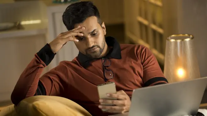 फोनकडे पाहणारा माणूस