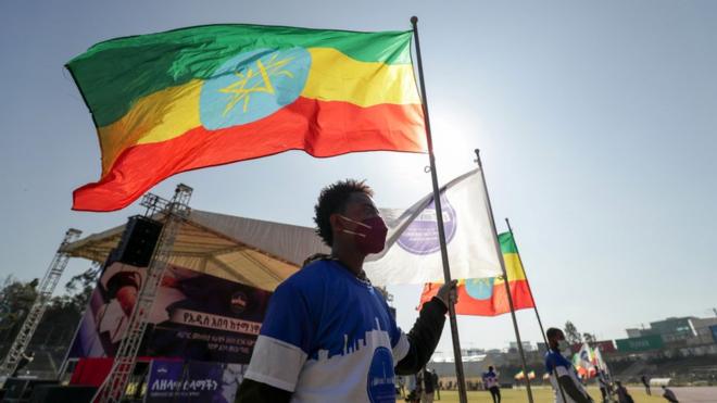 A volunteer holds an Ethiopian flag during a blood donation ceremony for the injured members of Ethiopia's National Defense Forces (ENDF) fighting against Tigray's special forces on the border between Amhara and Tigray, at the stadium in Addis Ababa, Ethiopia November 12, 2020.