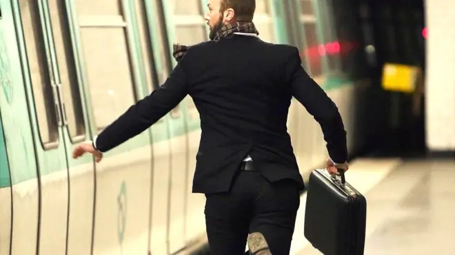 Un hombre corriendo para abordar un tren