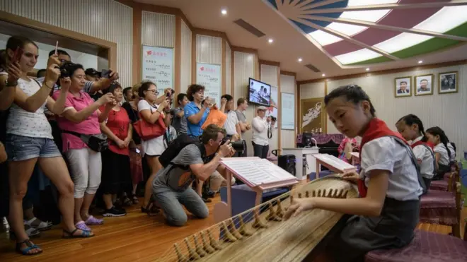 지난 7월 평양을 방문한 외국인 관광객들이 공연 모습을 촬영하고 있다