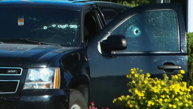 A bullet-riddled vehicle near the shooting site