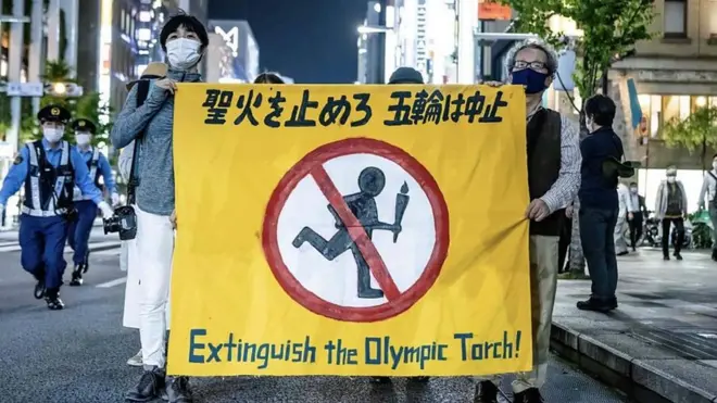 Japanci drže znak na kome piše „Ugasite olimpijski plamen"