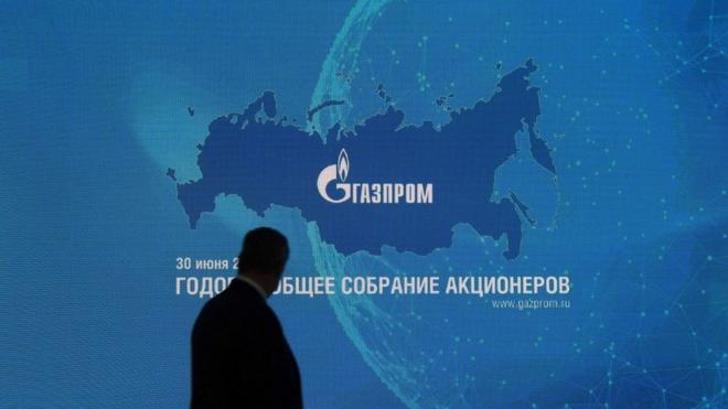 Черная тень на фоне эмблемы "Газпрома"
