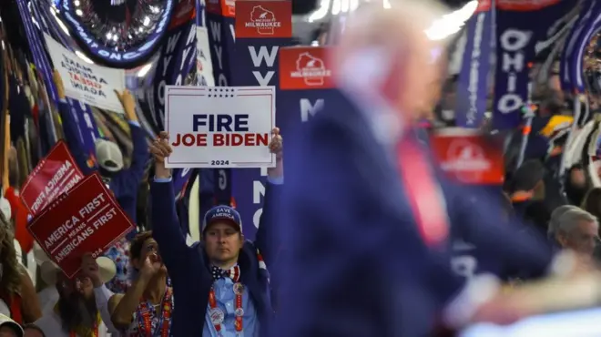 Pristalica Trampa na preidzbornom skupu drži parolu na kojoj piše: „Otkaz Džozefu Bajdenu"