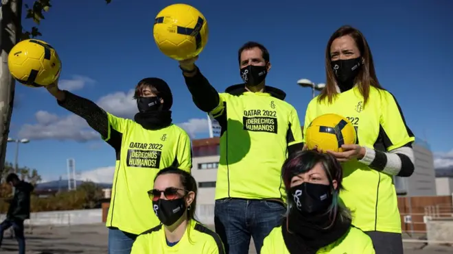 لاعبون محتجون على سوء معاملة العمال في قطر.