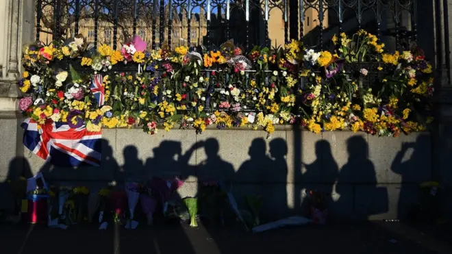 Цветы, оставленные в память о погибших у здания парламента в Лондоне