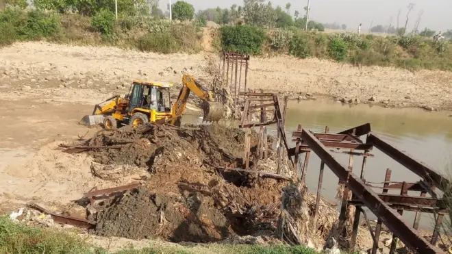 The earth excavator dismantling the bridge