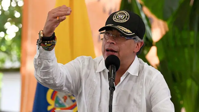 Gustavo Petro, con camisa blanca, habla ante un micrófono con el brazo