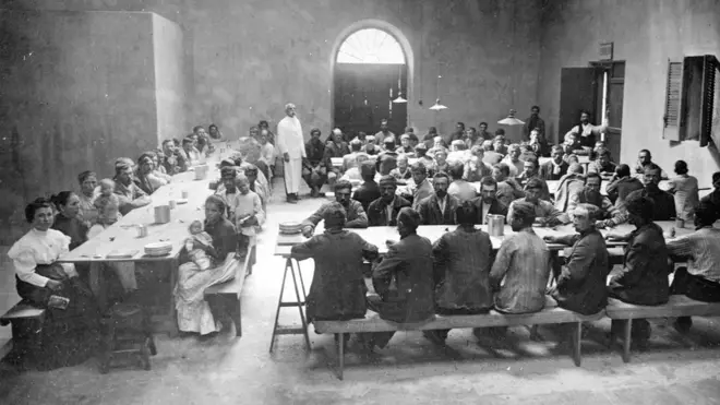 Inmigrantes comiendo en uno de los pabellones de la Isla de Flores.