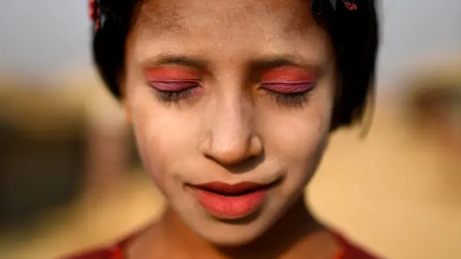 Rohingya refugee Amina poses for a photograph as she wears thanaka paste at Kutupalong camp in Cox's Bazaar, Bangladesh