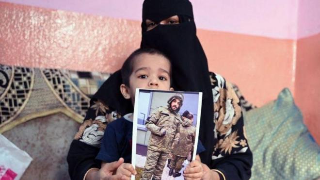 Mohammed Asfan's wife and child hold a picture of him