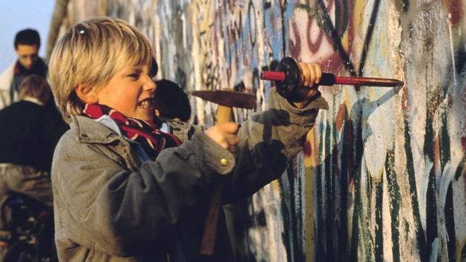 Criança quebra Muro de Berlim