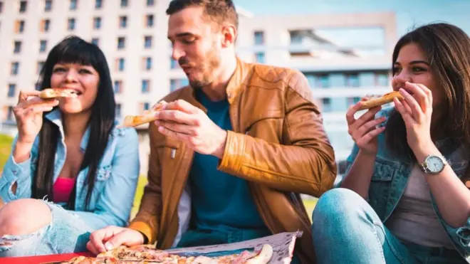 Amigos comendo pizza