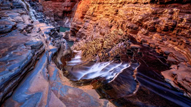 Cascada, rocas y pozo