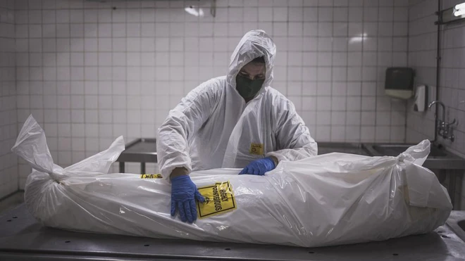 เจ้าหน้าที่ของสถานประกอบพิธีศพแห่งหนึ่งในกรุงพริทอเรียของแอฟริกาใต้ กำลังจัดการกับศพติดเชื้อ