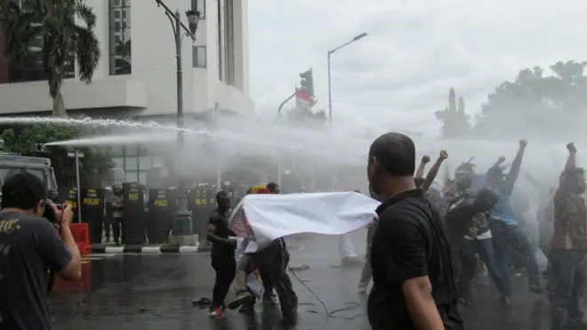 Polisi menyemprotkan air dengan water canon ke arah kerumunan pengunjuk rasa