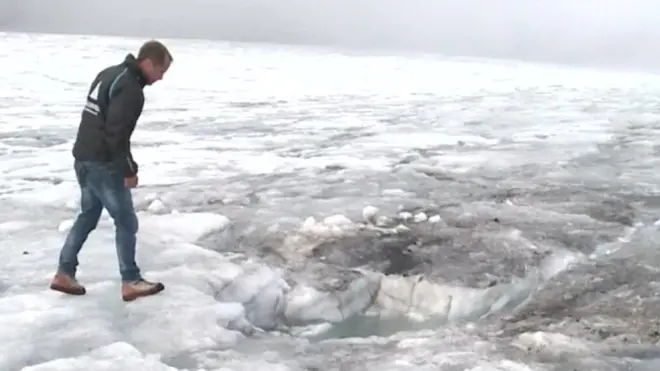 Local businessman Bernhard Tschannen shows where the bodies were found in the ice