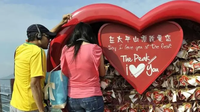 شاب وشابة أمام ديكور على شكل قلب